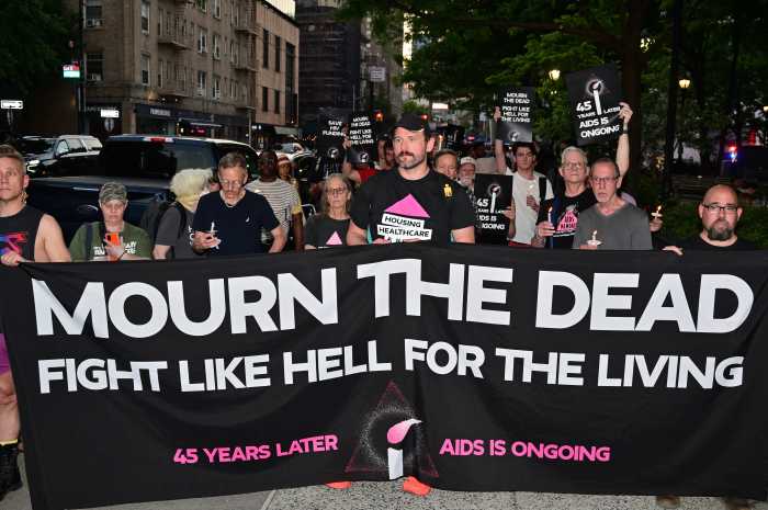 Community members carry a banner calling to mourn the dead and fight for the living.