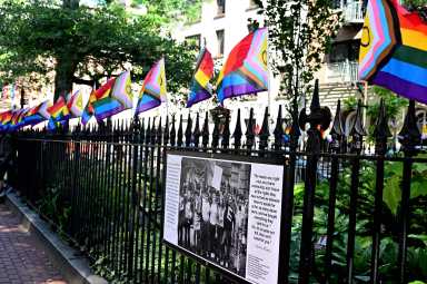 Small Rainbow Flags line the fence at Christopher Park.