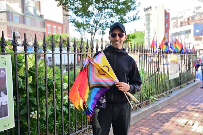 Zahir Babvani helps install small Rainbow Flags on May 31.