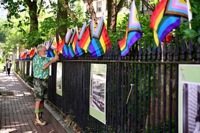 Steven Love Menendez installs Rainbow Flags along the perimeter of Christopher Park.