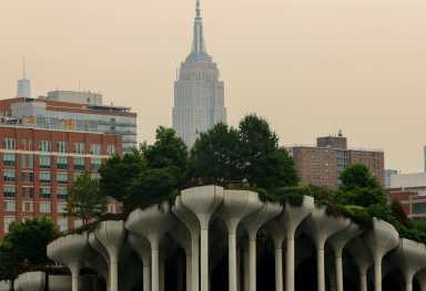 People stand at the top of 'Little Island' park along the Hudson River on Manhattan's west side with the Empire State Building behind seen through a cover of wildfire smoke in New York City, U.S., July 16, 2026.
