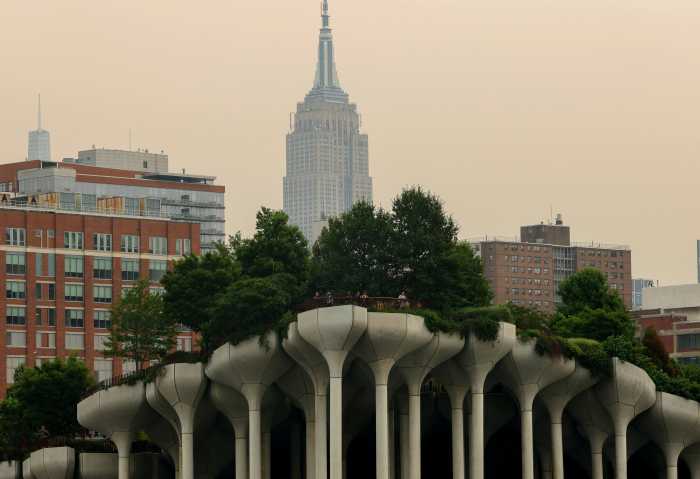 People stand at the top of 'Little Island' park along the Hudson River on Manhattan's west side with the Empire State Building behind seen through a cover of wildfire smoke in New York City, U.S., July 16, 2026.